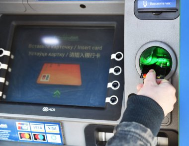 MINSK BELARUS-04.30.2020: Kadın eli ile ATM yakın plan. NCR SelfServ Cash disppense ATM kartı olan bir kız ATM 'den nakit çekti.