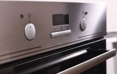 Fırının ön paneli. Gümüş elektrikli fırının yuvarlak düğmesi. Elektrikli fırının arka planı