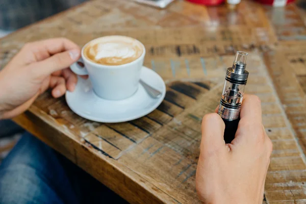 vape veya elektronik sigara ve kahve içme adam