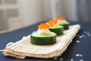 meze. Salatalık havyar ve bambu hasır üzerinde krem peynir ile