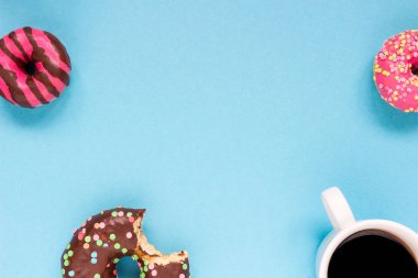 Mavi zemin üzerine kahve ile tatlı çörek.