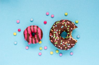 Mavi arka plan üzerinde renkli şekerler ile tatlı çörek.