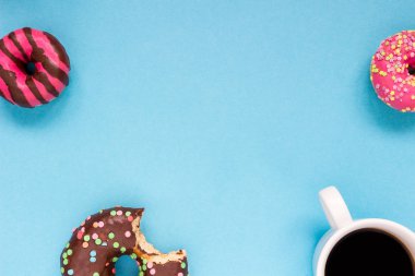 Mavi zemin üzerine kahve ile tatlı çörek.