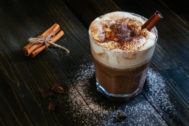 krema ve tarçın siyah masada sıcak çikolata