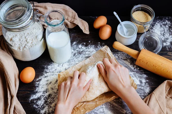 Женские руки готовят тесто на кухне. Выпечка ингредиентов на деревянном столе — стоковое фото