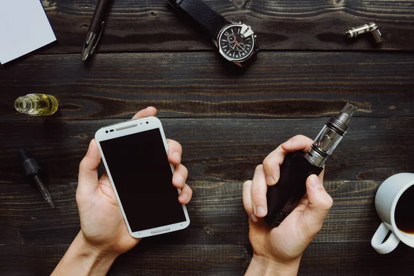 Man smoking vape or electronic cigarette and using smartphone. V — Stock Photo, Image