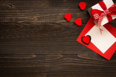 Sevgiliye arka plan. Hediye kutusu, kırmızı kalp, ahşap masa üzerinde kopya alanı ile Sevgililer günü kartı
