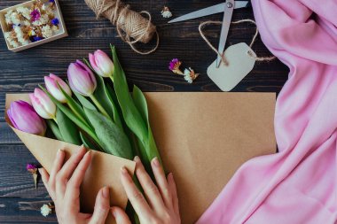 Ahşap masa üzerinde taze güzel Lale buketi hazırlanıyor çiçekçi.