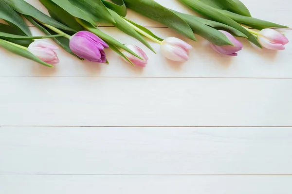 Hermosos tulipanes frescos con papel sobre el fondo de madera con espacio para copiar — Foto de Stock