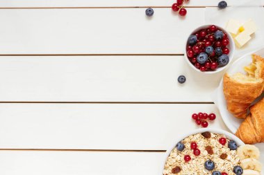 Sağlıklı kahvaltı ile yulaf gevreği, çilek, kruvasan kopya alanı, üstten görünüm Beyaz ahşap tablo