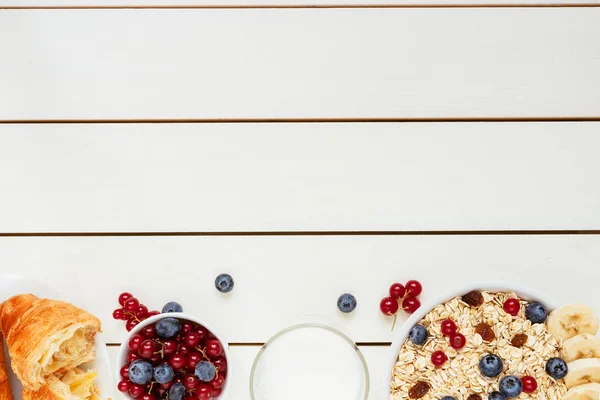Desayuno saludable con bayas, croissant y leche en la mesa de madera blanca con espacio para copiar, vista superior — Foto de Stock