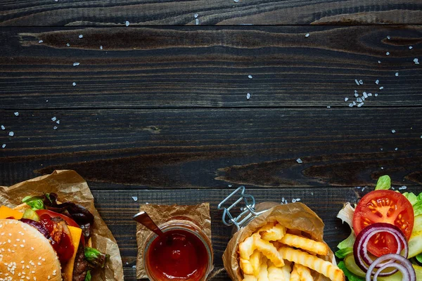 Świeże pyszne hamburgery, frytki, sos i pić na widok drewniany blat, z miejsca kopii — Zdjęcie stockowe