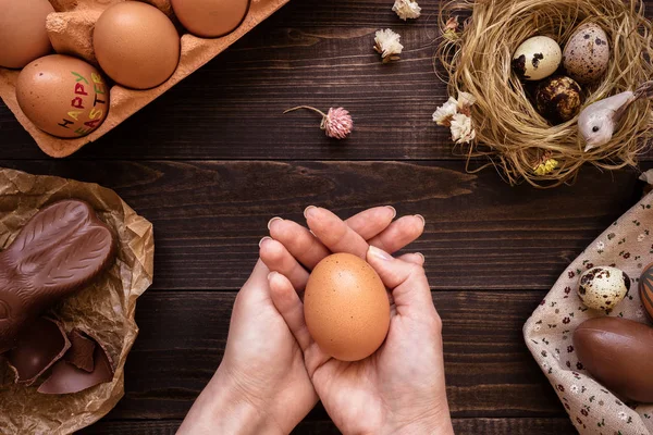 Paskalya yumurtası ahşap masa üzerinde tutan eller