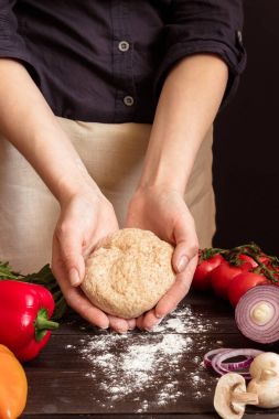 Kadın hamur pizza yemeye hazırlanıyor. Hamur mutfakta holding eller.