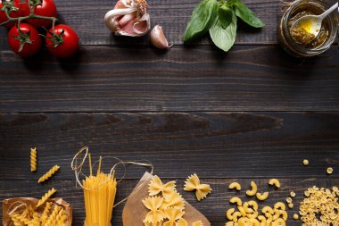 Karışık makarna ve sebzeler koyu ahşap masa üstü görünümle kopya alanı kurutulmuş