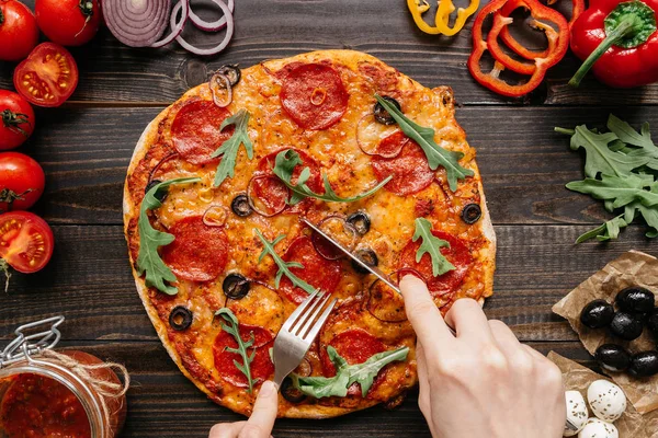 Comer pizza caliente deliciosa, vista superior. Ingredientes de pizza en la mesa de madera — Foto de Stock