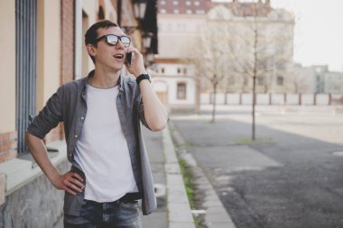 Mutlu genç hipster adam sokakta yürürken ve Evet