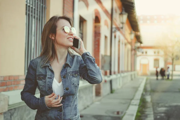 Jovem loira bonita andando na rua, falando por telefone — Fotografia de Stock