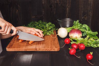 Ahşap masa üzerinde sebze kesme sağlıklı mutfakta yemek eller
