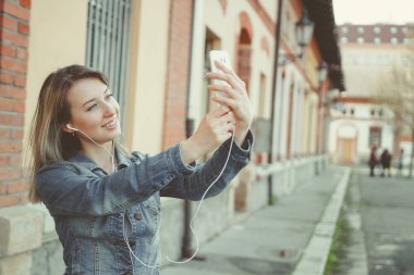 Selfie onun smartphone ile yapma sokakta, yürüyen mutlu genç kadın