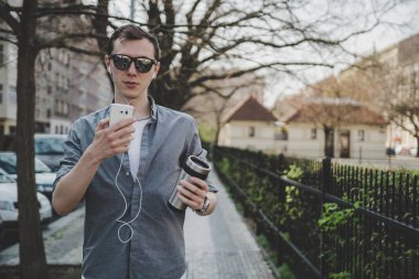 Genç hipster adam sokakta yürürken ve onun smartphone kullanarak açık portre