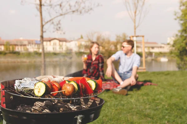 Friends having outdoor barbecue. Grill with various barbecue, selective focus