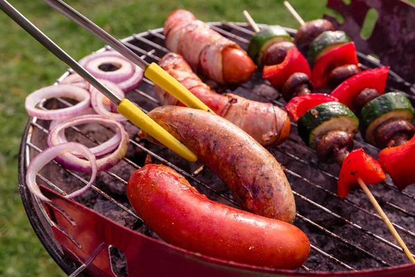 Cucina a mano alla griglia con vari deliziosi barbecue all'aperto, messa a fuoco selettiva — Foto Stock