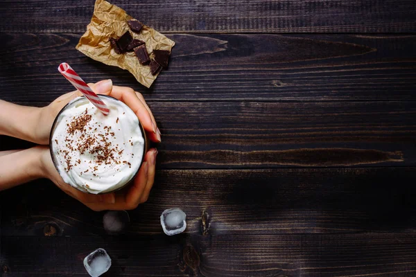 Hands holding Ice coffee drink on the wooden table, with copy space. Top view — Stock Photo, Image