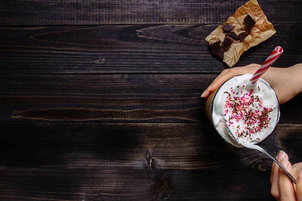 Hands holding Ice coffee drink on the wooden table, with copy space. Top view — Stock Photo, Image