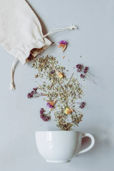 Hora del té. Té de hierbas seco y taza en el fondo gris, vista superior —  Fotos de Stock