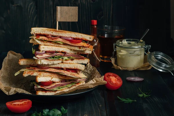 신선한 맛 있는 클럽 샌드위치와 어두운 나무 테이블에 소스 — 스톡 사진