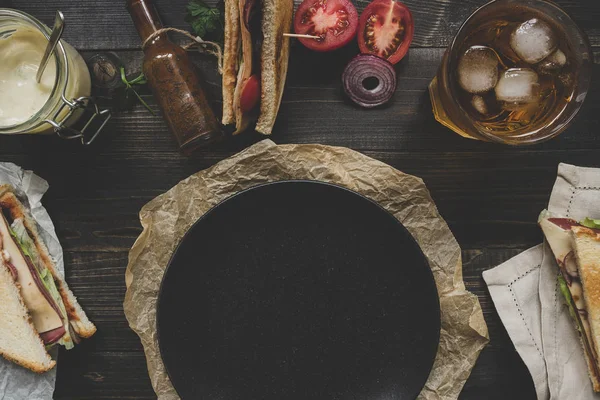 黒プレート、暗い木製のテーブル トップ ビューに新鮮な美味しいサンドイッチ。コピー スペース — ストック写真
