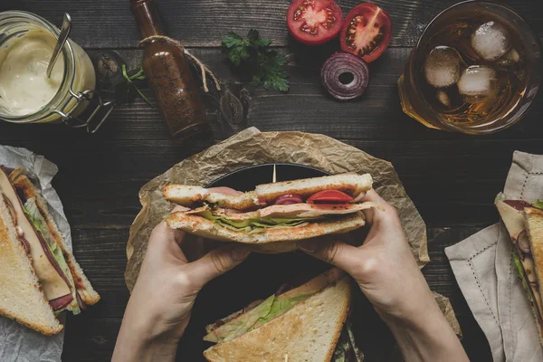 Widok z góry świeże pyszne sandwich club, sosy i napoje na drewniany stół ciemny, trzymając się za ręce — Zdjęcie stockowe