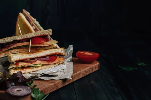 Свіжий смачний клубний бутерброд на дерев'яному темному столі з копією — стокове фото