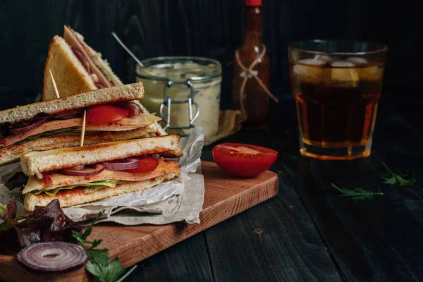 Sandwich de club fresco delicioso, salsas y bebida en la da de madera — Foto de Stock