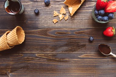 taze çilek, gözleme koni ve ahşap zemin üzerine çikolata sosu görünümü top. Dondurma arka plan kopya alanı ile