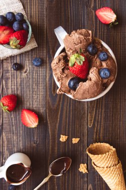 Lezzetli dondurma taze meyveleri ve ahşap zemin, üstten görünüm üzerine çikolata sosu ile
