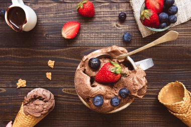 Lezzetli dondurma taze meyveleri ve ahşap zemin, üstten görünüm üzerine çikolata sosu ile