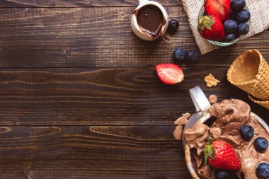 Lezzetli dondurma taze meyveleri ve ahşap zemin, üstten görünüm üzerine çikolata sosu ile.