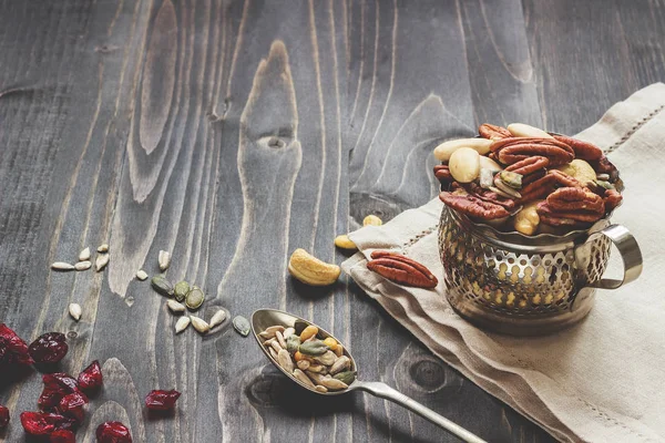 種子とドライ フルーツとナッツを混ぜます。カシュー ナッツ、アーモンド、ペカン木のテーブルの上 — ストック写真