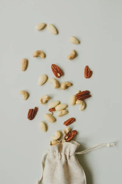 Nuts mix. Cashews, almonds and pecans on the gray background, top view — Stock Photo, Image