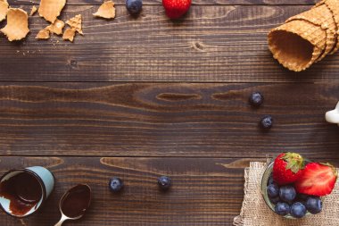 taze çilek, gözleme koni ve ahşap zemin üzerine çikolata sosu görünümü top. Dondurma arka plan kopya alanı ile