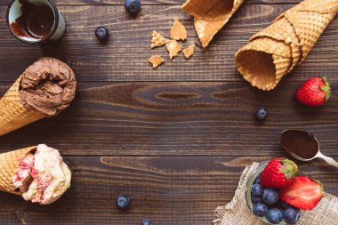 Taze meyveleri ve ahşap zemin, üstten görünüm üzerine çikolata sosu ile dondurma. Kopya alanı