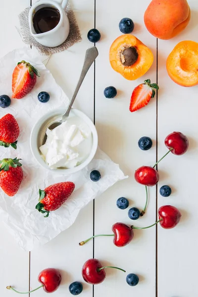 Frutas de verano. Bayas jugosas frescas y albaricoque en la mesa de madera blanca, vista superior — Foto de Stock