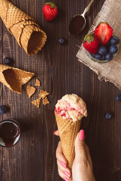 Ice-cream with fresh berries and chocolate sauce on the wooden background, top view — Stock Photo, Image