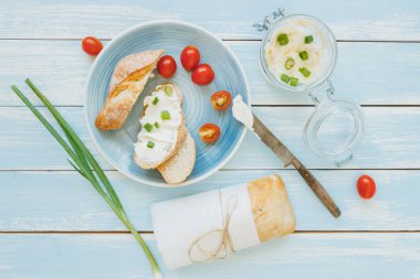 Yaz kahvaltı. Ciabatta ekmeği ile krem peynir ve domates mavi ahşap tablo