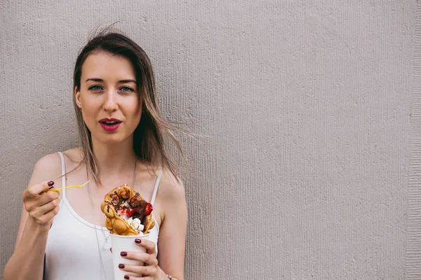 Genç kadın ile meyve, çikolata ve şekerleme, kopya alanı ile kabarcık gözleme yemek