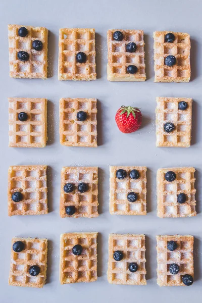 Fondo de gofres belgas con fresas y arándanos sobre fondo gris — Foto de Stock