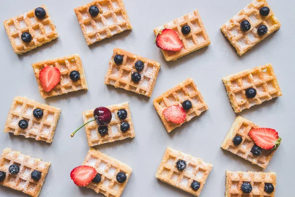 Fondo de gofres belgas con fresas y arándanos sobre fondo gris — Foto de Stock