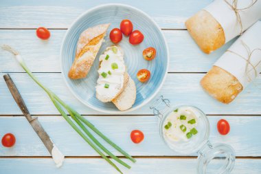 Yaz kahvaltı. Ciabatta ekmeği ile krem peynir ve domates mavi ahşap tablo